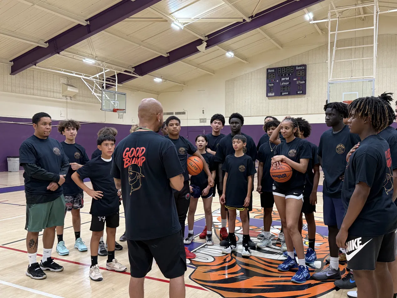 Players listening to Coach Sandy during instruction at midcourt